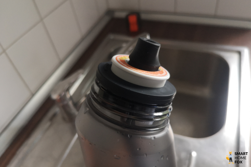 Ein Bild, auf dem man den runtergedrückten Duft-Pod auf der Flasche sieht.