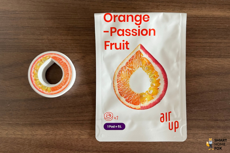 Ein Bild, welches den Pod und die Verpackung des Geschmacks Orange-Passionsfrucht zeigt.