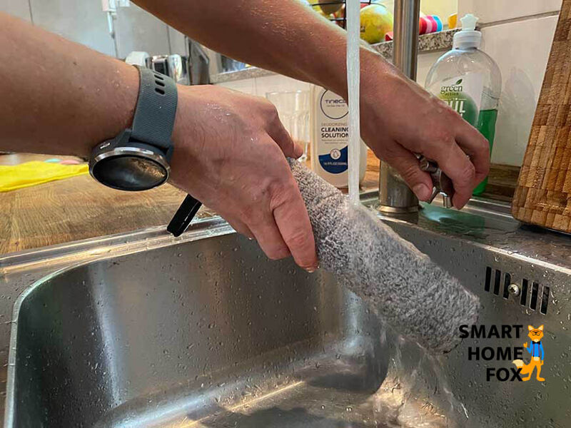 Man sieht, wie die Bürstenwalze eines Akku-Saugwischers gereinigt wird.