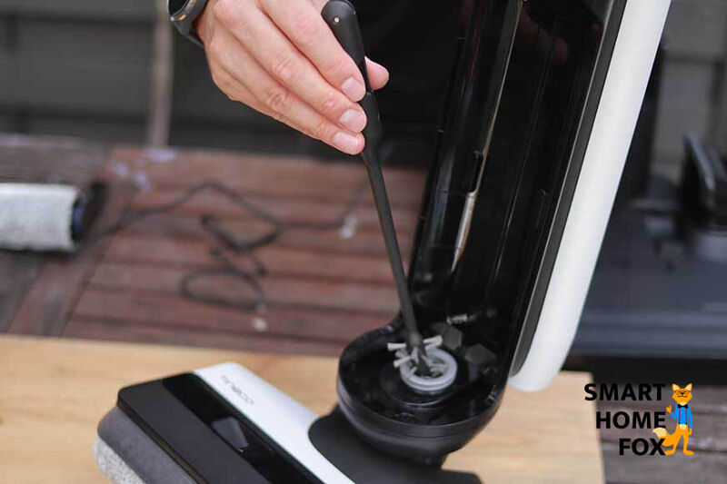 Man sieht, wie die Leitungen eines Akku-Wischsaugers gereinigt werden.