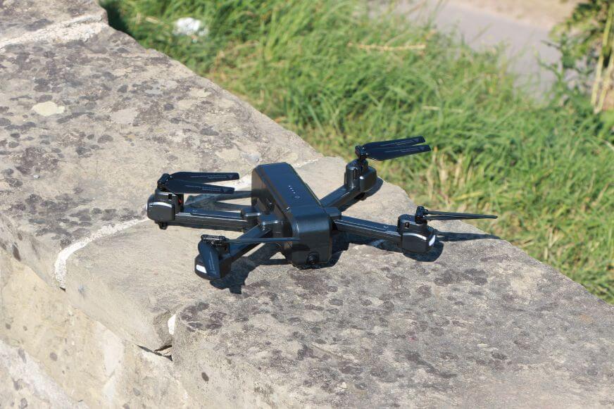Die Maginon QC 90 Aldi Drohne liegt startbereit, mit den 4 Rotoren (Quadrocopter) ausgeklappt auf einer Mauer