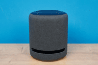 Amazon Echo Studio steht auf dem Tisch vor einem hellblauen Hintergrund