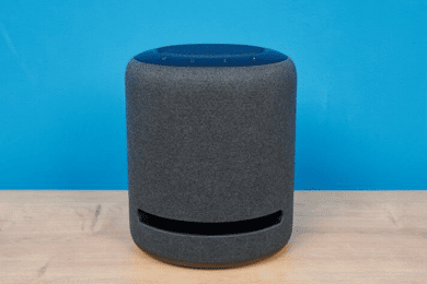 Amazon Echo Studio steht auf dem Tisch vor einem hellblauen Hintergrund