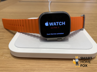 Apple Watch Ultra 2 auf Ladepad mit orangenen Armband