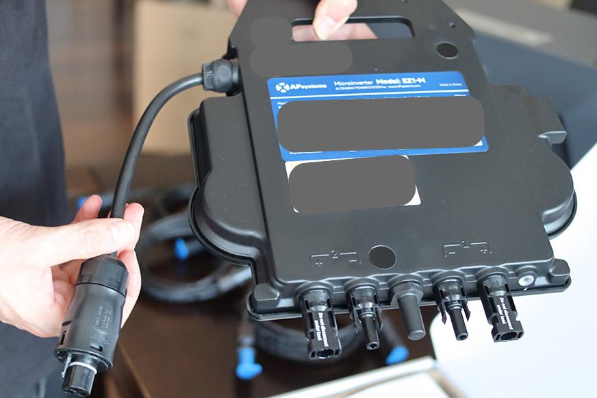 Der APSystems EZ-1 M800 Mikrowechselrichter wird in der Hand gehalten.