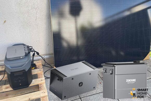 Ein Balkonkraftwerk Speicher wurde nachgerüstet und steht neben einem Solarmodul auf der Dachterrasse.