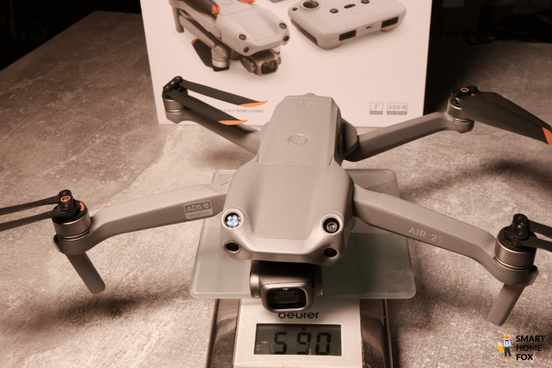 Die DJI Air 2S ist ausgeklappt, liegt auf einer Waage und wiegt 590 Gramm im Test