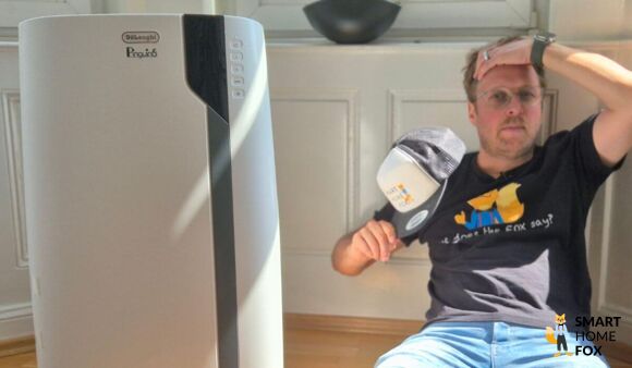 De'Longhi Pinguino PAC EX105 mobile Klimaanlage steht in einem Buero neben einem Schreibtisch