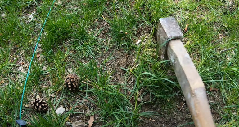 Draht für den Mähroboter, mit der Axt ausheben