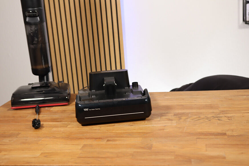 Dreame H15 Pro neben seiner Station auf dem Tisch.