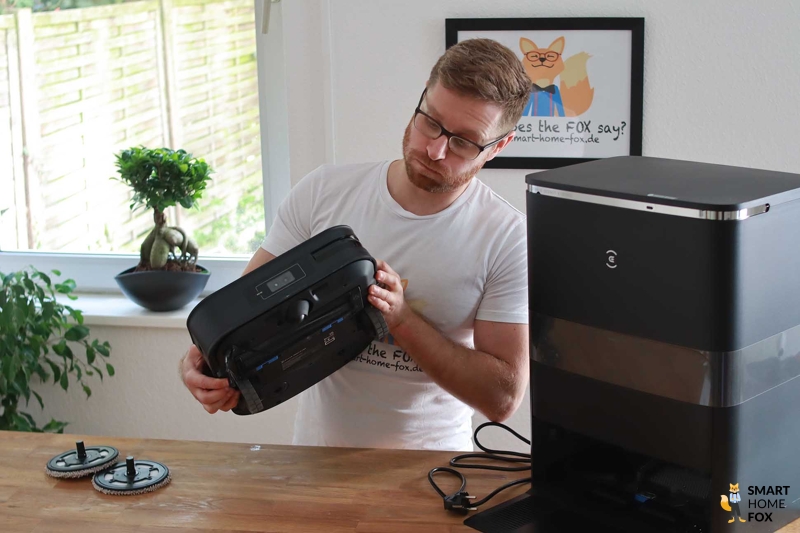 Der Ecovacs Deebot X2 OMNI steht auf dem Tisch und wird vom Smart Home Fox Mitarbeiter angeschaut.