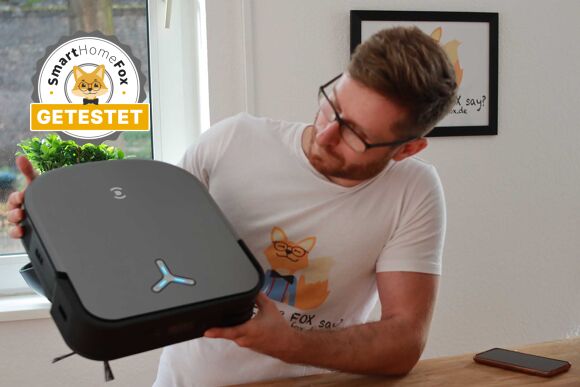 Der ECOVACS DEEBOT X2 OMNI wird beim Testverfahren in den Händen gehalten.