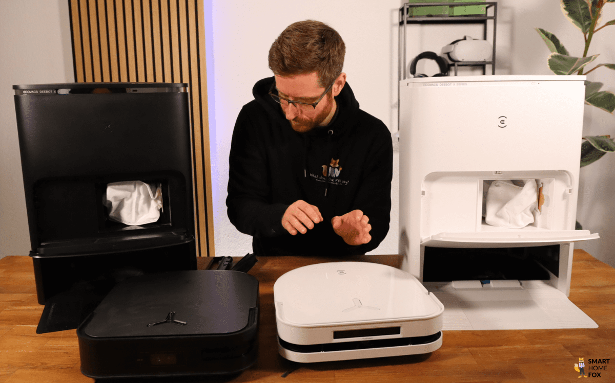 Der DEEBOT X5 OMNI und der X3 OMNI stehen auf dem Tisch nebeneinander, mit den Stationen im Hintergrund.