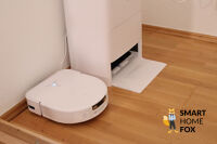 ECOVACS DEEBOT X5 OMNI und die OMNI Station stehen nebeneinander auf dem Laminat