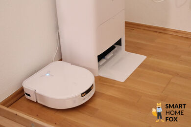 ECOVACS DEEBOT X5 OMNI und die OMNI Station stehen nebeneinander auf dem Laminat