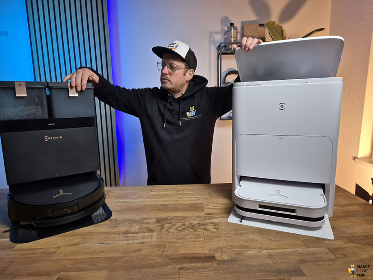ECOVACS DEEBOT X8 PRO OMNI steht neben dem DEEBOT X5 OMNI mit unserem Smart Home Fox Experten im Hintergrund.