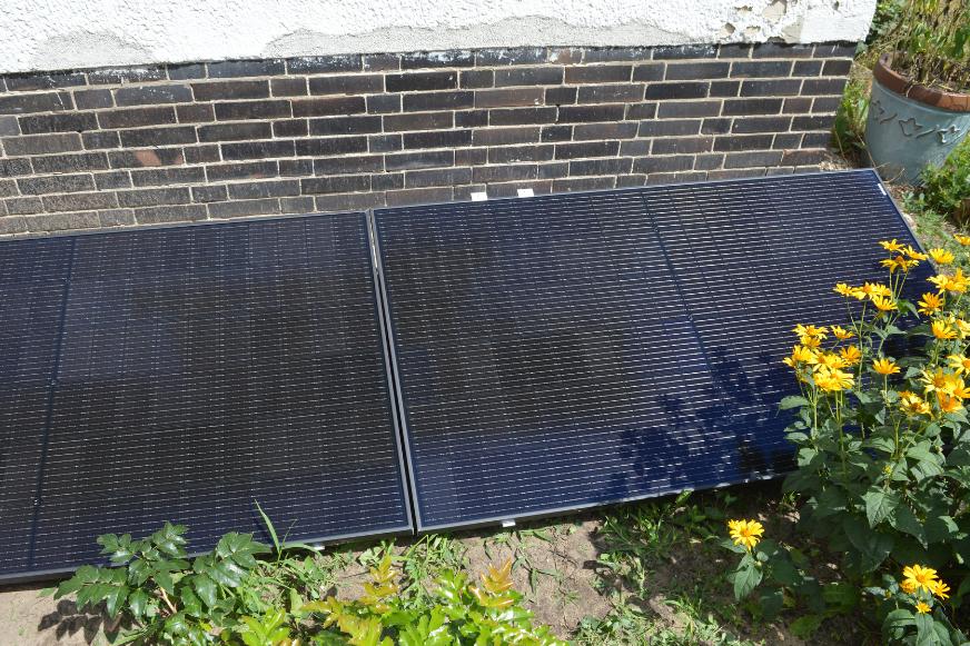 Das EcoFlow PowerStream Balkonkarftwerk steht im Garten.