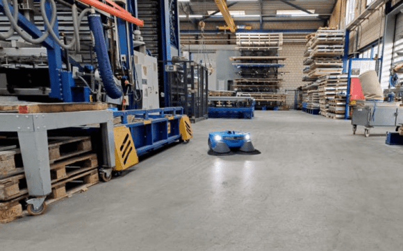 Ein Industrie-Saugroboter reinigt eine Produktionshalle im Test.