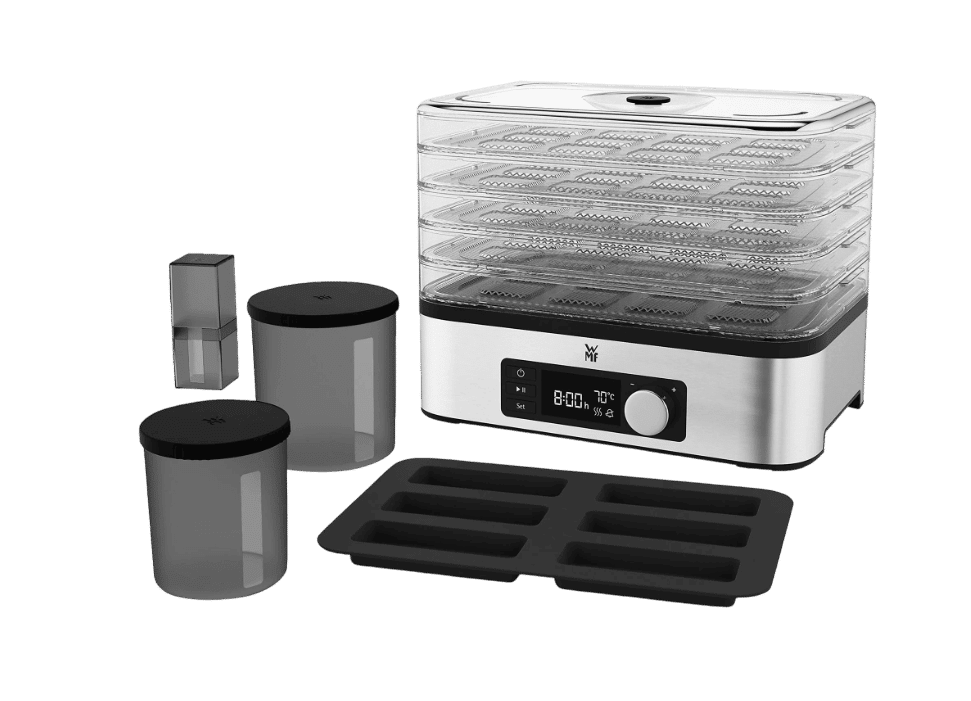Der WMF 04.1525.0011 KÜCHENminis® Snack to go Dörrautomat (250 Watt) ist mit unterschiedlichem Zubehör und den Dörrfeldern zu sehen,