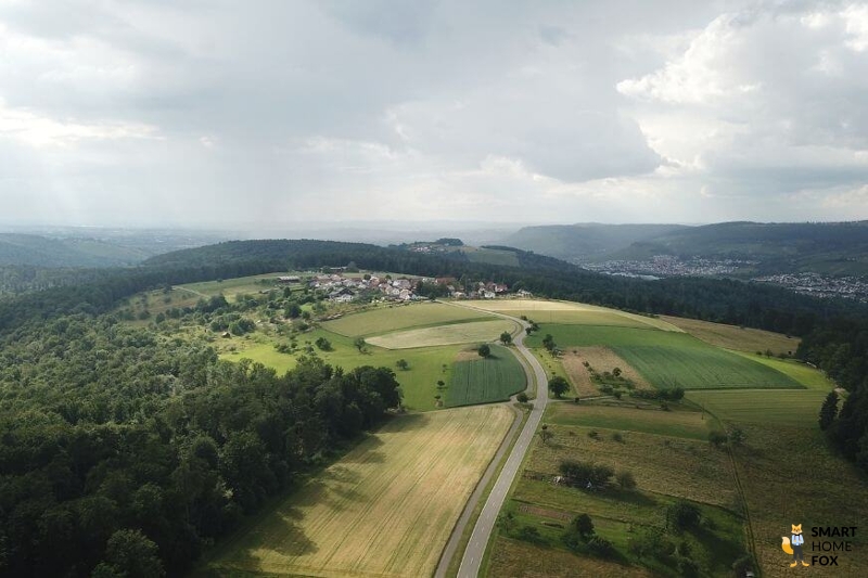 Ein Bild aus der Höhe von der Landschaft und einem Dorf von der DJI Mini 2 Drohne