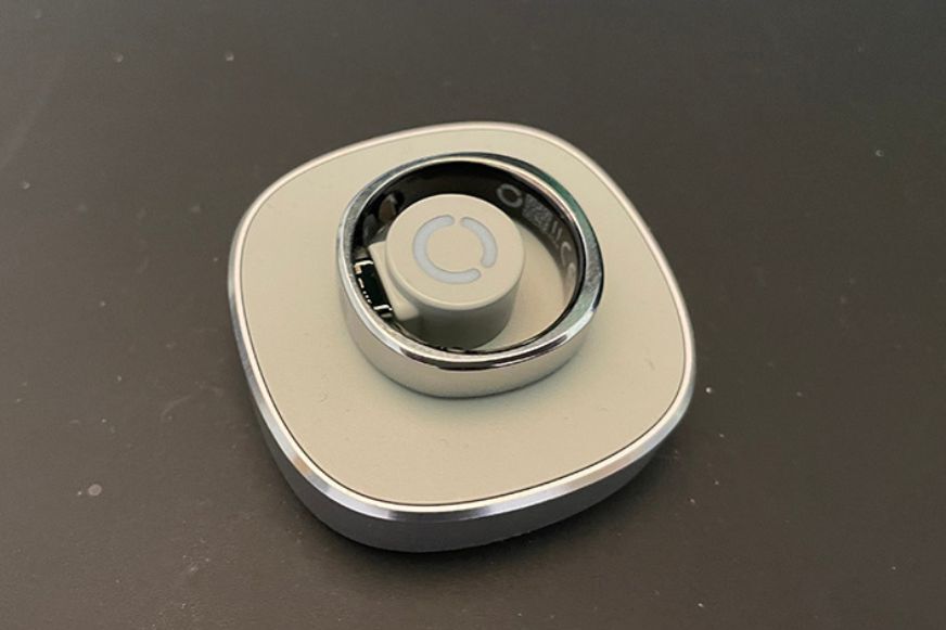 Der RingConn Gen 2 Air Smarter Ring liegt auf der Ladestation.
