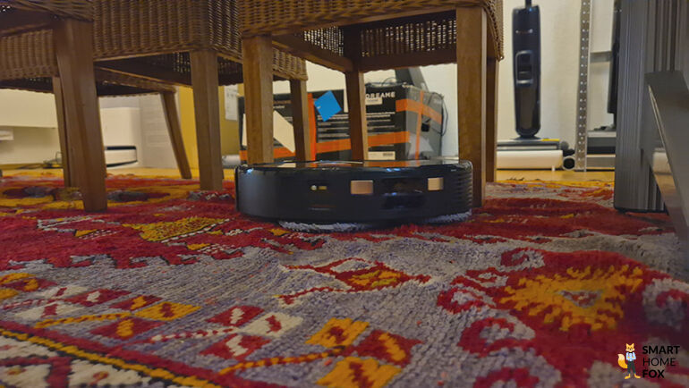 Roborock QRevo navigiert zwischen Stuhbeinen unter dem Tisch.