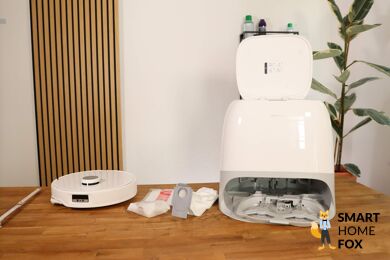 Der Roborock Qrevo Curv steht samt gesamten Lieferumfang auf dem Tisch.