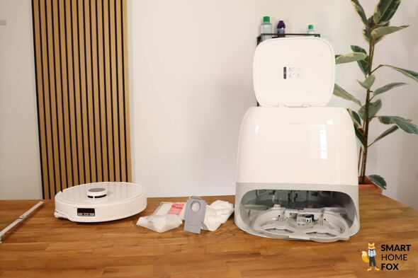 Der Roborock Qrevo Curv steht samt gesamten Lieferumfang auf dem Tisch.