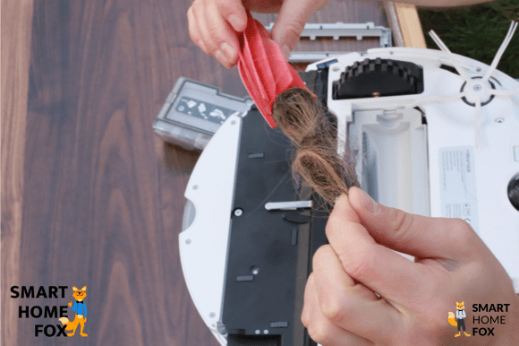 Ein Saugroboter wird durch einen Smart Home Fox Mitarbeiter gewartet.