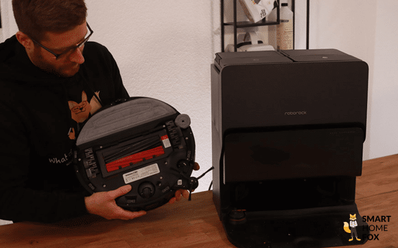 Roborock S8 MaxV Ultra steht im Test auf dem Tisch und wird von einem Smart Home Fox Mitarbeiter angeschaut.