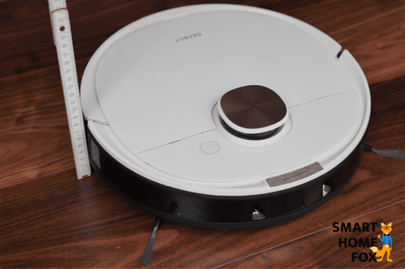 Die Höhe eines flachen Saugroboters wird mit einem Lineal gemessen