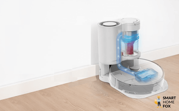 Ein Saugroboter mit Absaugstation ohne Beutel steht auf dem Boden.