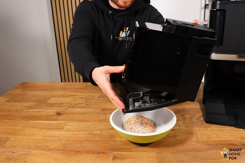 Der Staubbehälter der Shark Nevertouch 2-in-1 Station wird entleert.