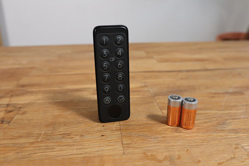switchbot keypad steht neben batterien auf dem tisch