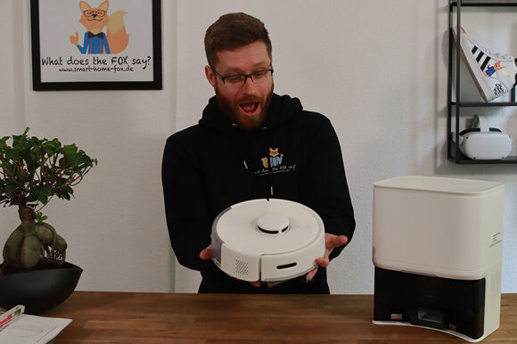 Der SwitchBot K10+ Saugroboter wird in den Händen gehalten.