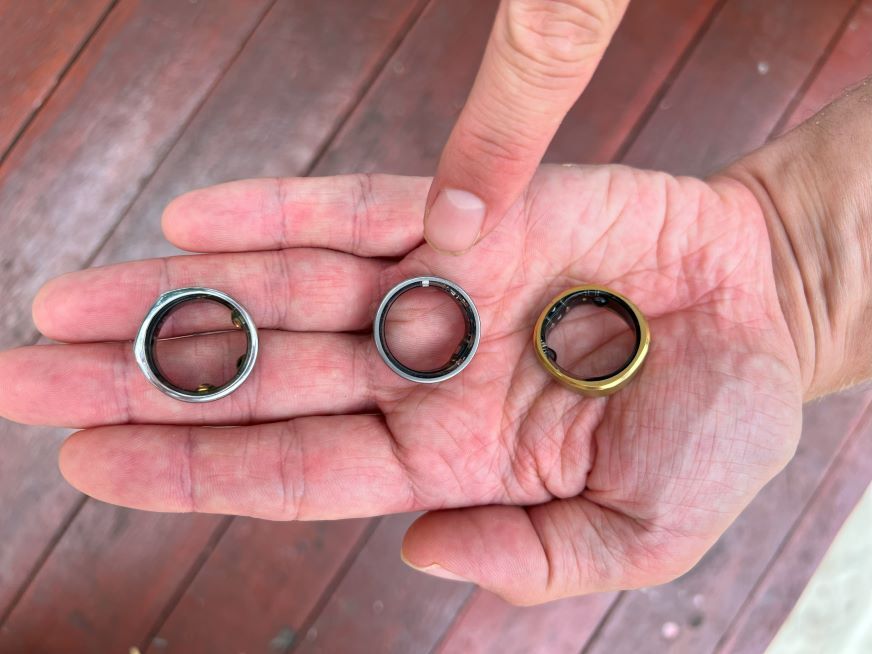 Ultrahuman Ring Air auf der Hand neben zwei anderen Ringen