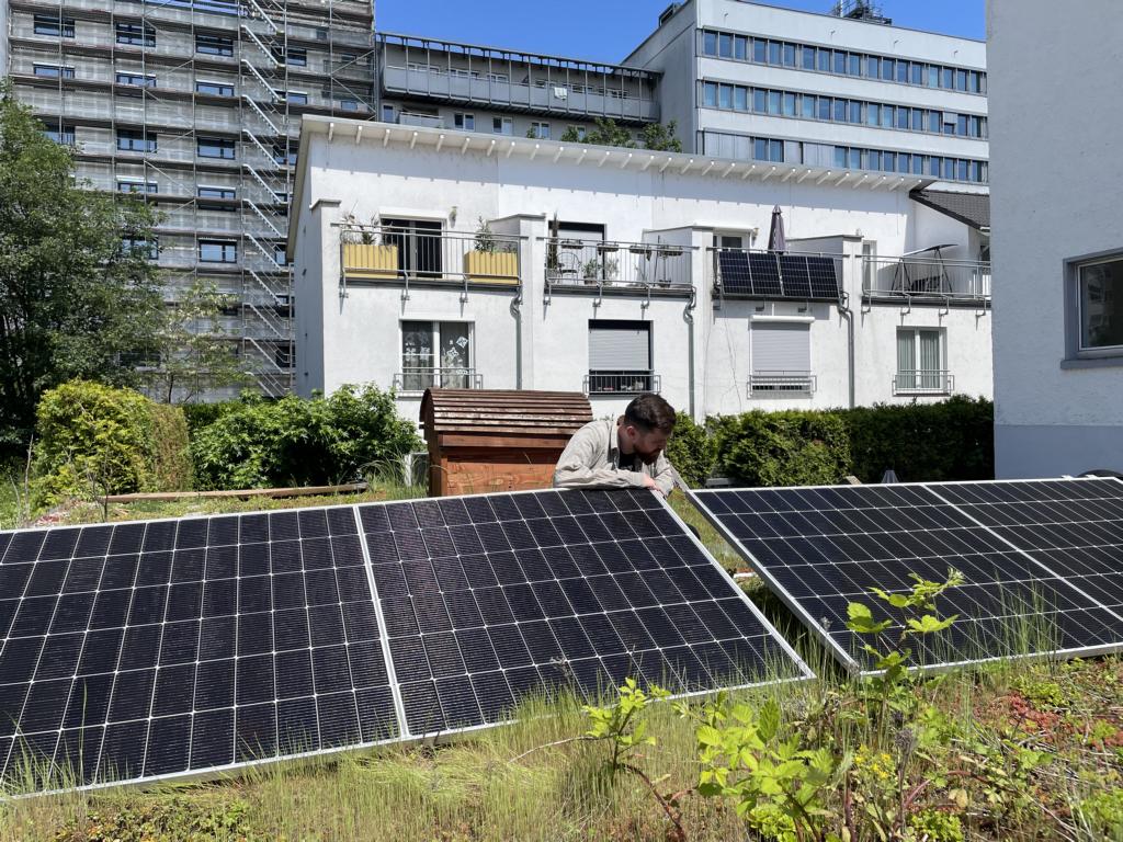 Yuma Flat XL 1170+ Bifaziale Solarmodule stehen mit Flachdach Halterung aufgebaut auf dem Garagendach un dder Smart-Home-Fox Experte sitzt dahinter..