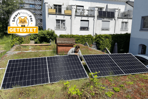 Yuma Flat XL (1160+) Balkonkraftwerk Solarmodule sind im Test auf der Flachdachhalterung aufgebaut und frontal zu sehen, der Smart-Home Experte und Tester sitzt dahinter.