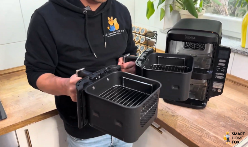 Beide Garkörbe der Ninja Double Stack Heißluftfritteuse SL400EU werden gleichzeitig aus dem Gerät entnommen – die einfache Handhabung der Schubladen macht Reinigung und Befüllung besonders komfortabel.