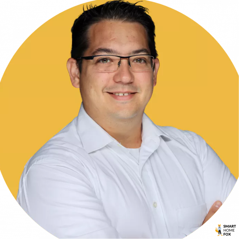 Maximilano Geist ist als TÜV Rheinland Akademie geprüfter Smart Home Fachberater und Fachplaner vor einem gelben Hintergrund zu sehen.