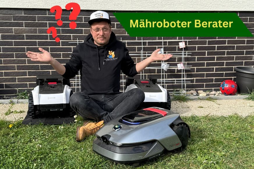 Der Mähroboter Berater sitzt neben einigen Mähroboter Modellen und hat den durchblick und bietet kostenlose Beratung an.