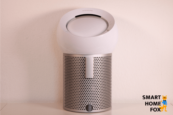 Der Dyson Pure Cool Me BP01 Tischventilator und Luftreiniger steht auf einem Tisch vor einer Wand